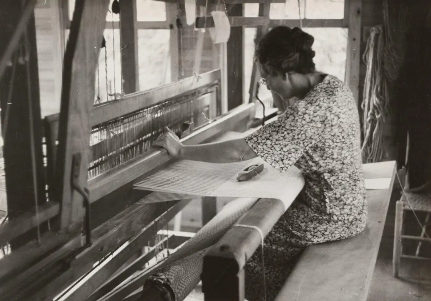 An artisan hand-weaving pashmina on a traditional pit loom.